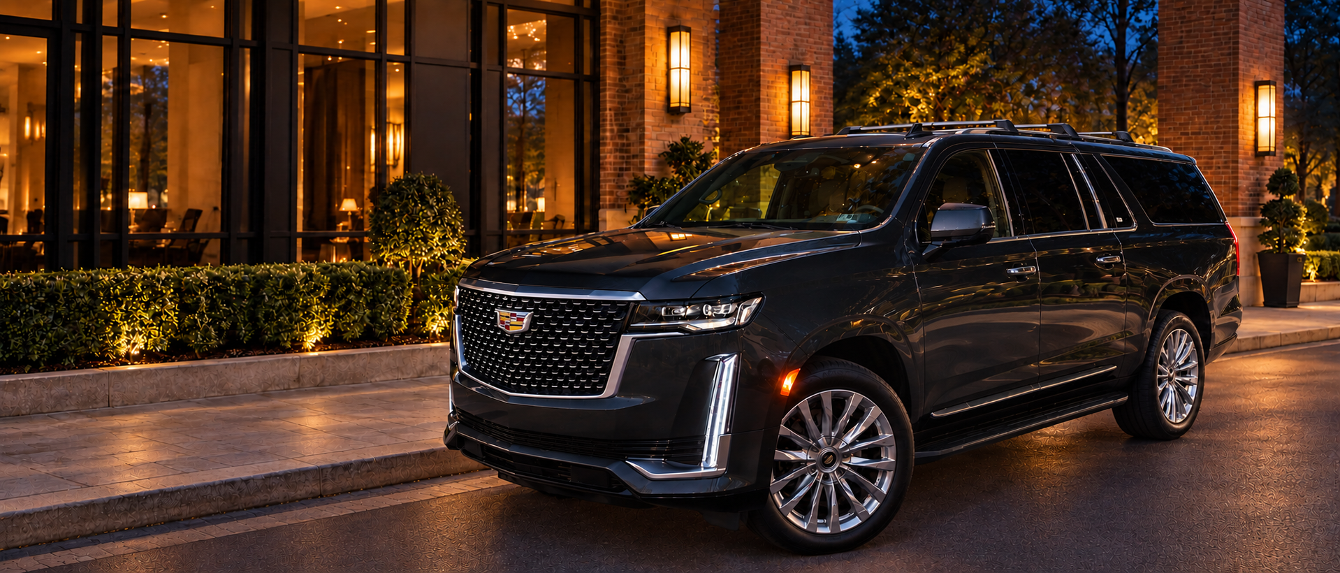 Cadillac Escalade ESV at a hotel entrance at dusk